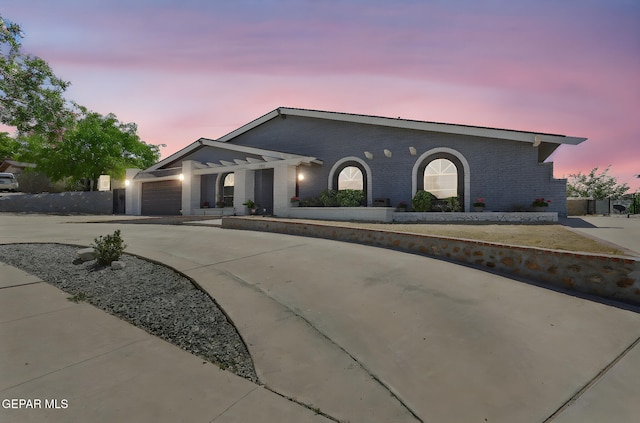 view of front facade with brick siding, driveway, and a garage