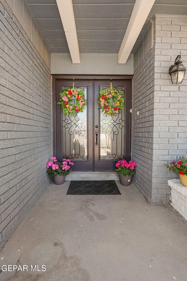 view of exterior entry featuring brick siding