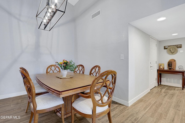 dining space with baseboards, light wood-style floors, a chandelier, and recessed lighting