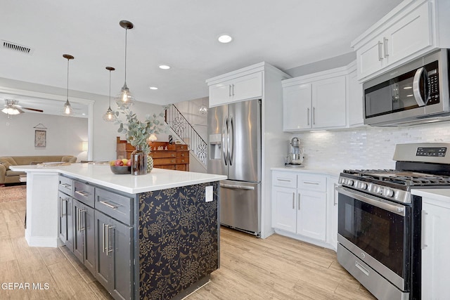 kitchen with stainless steel appliances, white cabinetry, open floor plan, light wood-type flooring, and recessed lighting