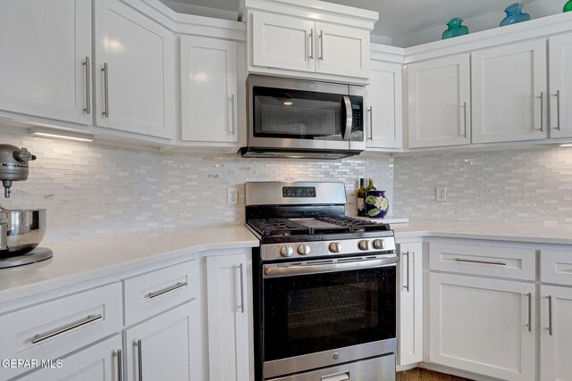 kitchen featuring appliances with stainless steel finishes, light countertops, white cabinetry, and backsplash