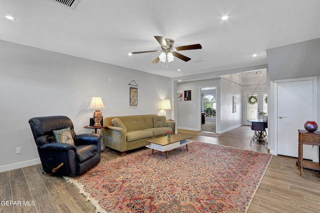 living area featuring a ceiling fan, wood finished floors, baseboards, and recessed lighting