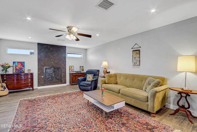 living room with ceiling fan, a fireplace, wood finished floors, healthy amount of natural light, and recessed lighting