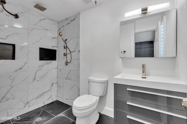 bathroom with toilet, vanity, and a marble finish shower