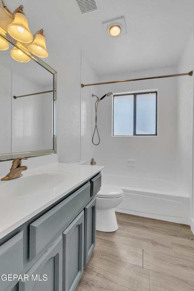 full bathroom featuring vanity, toilet, washtub / shower combination, and wood finished floors