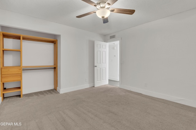 unfurnished bedroom featuring carpet flooring, a closet, baseboards, a ceiling fan, and a textured ceiling