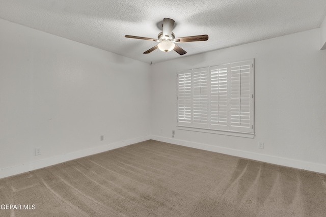 spare room with a ceiling fan, carpet, a textured ceiling, and baseboards