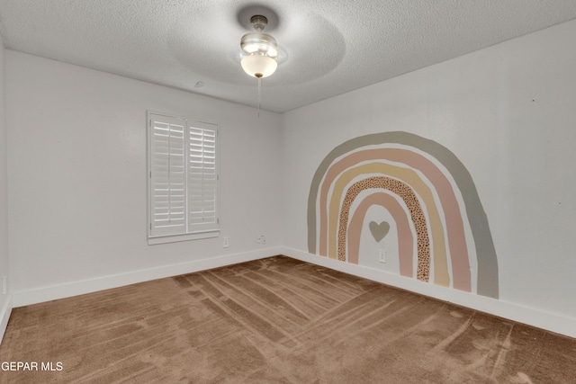 unfurnished room featuring carpet, a textured ceiling, baseboards, and ceiling fan