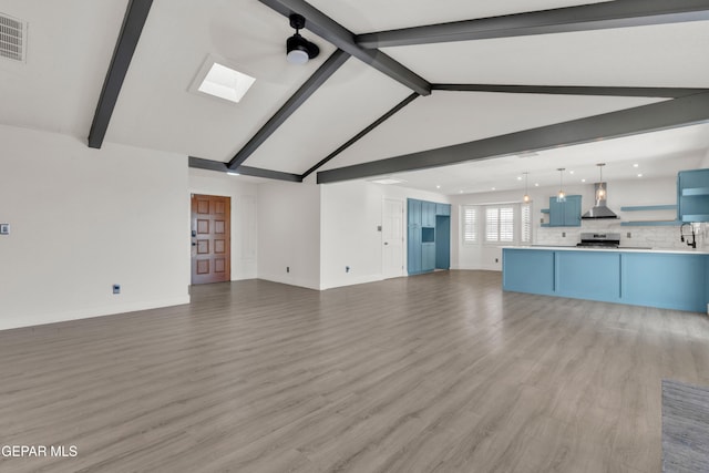 unfurnished living room featuring a skylight, baseboards, light wood-type flooring, recessed lighting, and a sink