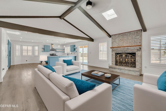 living area with a skylight, light wood-type flooring, a brick fireplace, recessed lighting, and baseboards