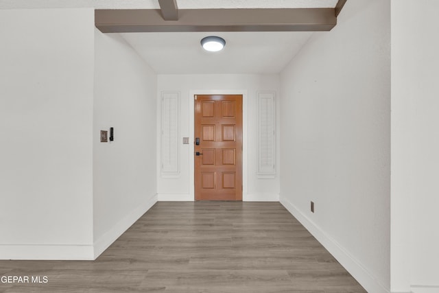 entrance foyer featuring wood finished floors, baseboards, and beamed ceiling
