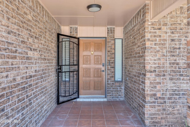 entrance to property featuring brick siding