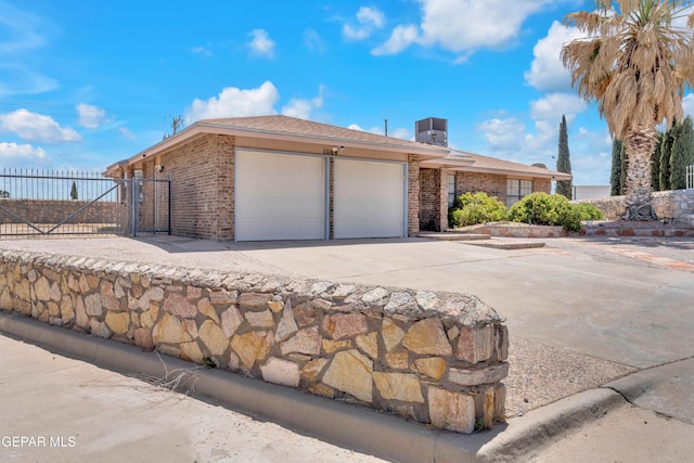 view of property exterior featuring an attached garage, brick siding, fence, and driveway
