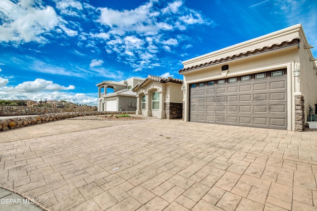 1403 Franklin Dell St, El Paso, TX 79912 - view of front of property featuring decorative driveway, a garage, and stucco siding
