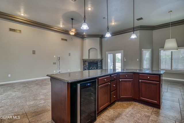 1403 Franklin Dell St, El Paso, TX 79912 - kitchen featuring wine cooler, baseboards, a stone fireplace, open floor plan, and ornamental molding