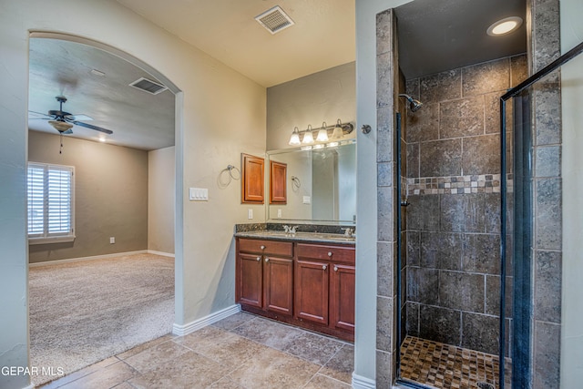 1403 Franklin Dell St, El Paso, TX 79912 - full bathroom featuring a stall shower, a ceiling fan, baseboards, double vanity, and stone finish floors