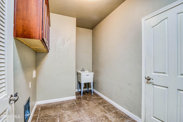 1403 Franklin Dell St, El Paso, TX 79912 - clothes washing area featuring cabinet space, baseboards, and dark stone finish flooring