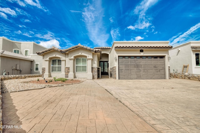 1403 Franklin Dell St, El Paso, TX 79912 - mediterranean / spanish-style house with decorative driveway, an attached garage, stucco siding, a tile roof, and french doors