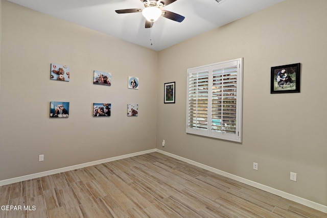 empty room with a ceiling fan, light wood-type flooring, and baseboards