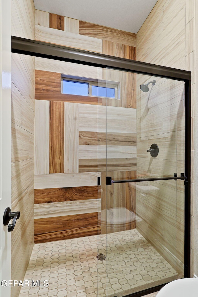 full bathroom featuring a shower stall and tile patterned floors
