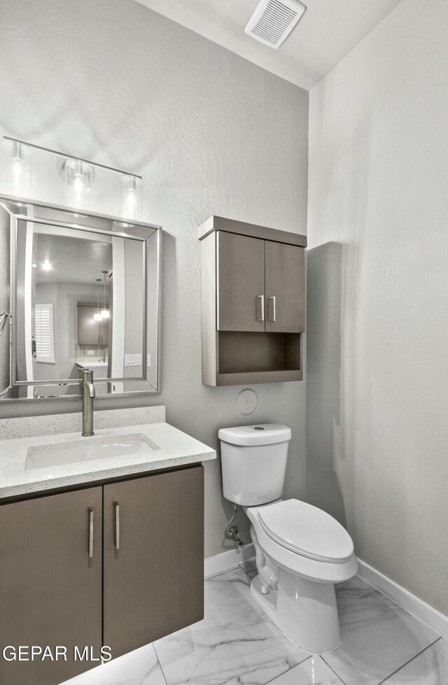 12627 Naes Way, El Paso, TX 79928 - bathroom featuring marble look tiles, baseboards, toilet, and vanity