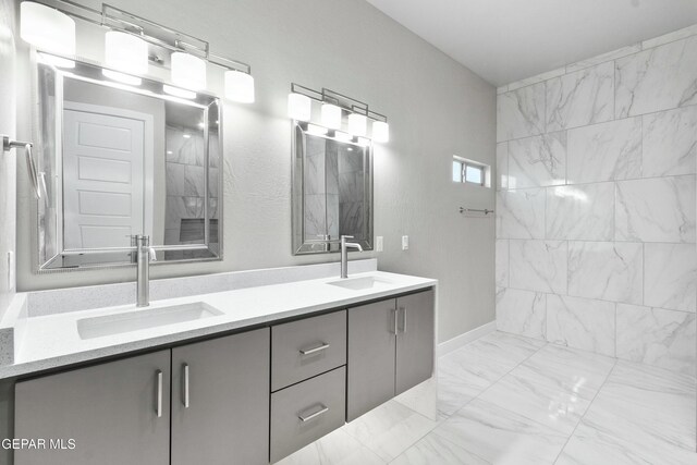 12627 Naes Way, El Paso, TX 79928 - full bath with marble look tiles, double vanity, and baseboards