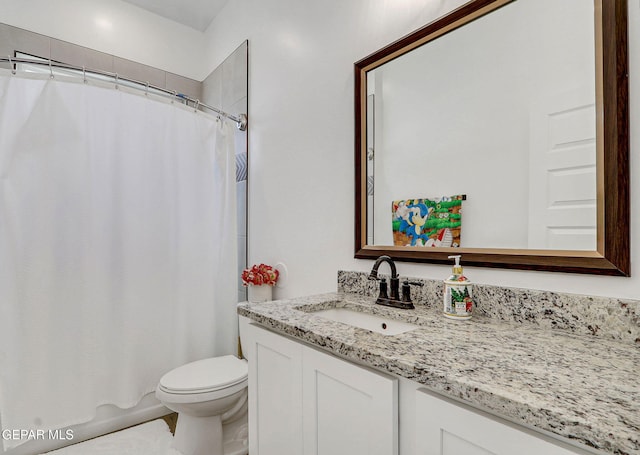 bathroom with toilet, vanity, and curtained shower