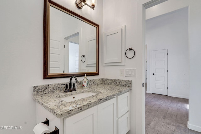 bathroom featuring vanity, baseboards, and wood finished floors
