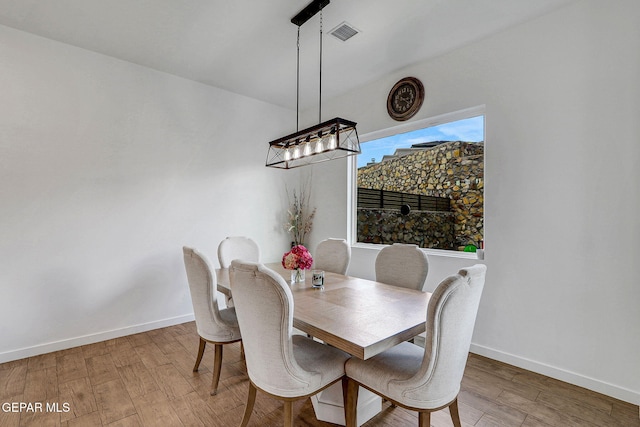 dining area with wood finished floors, baseboards, and a chandelier