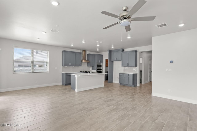 7461 Big Mountain Ct, El Paso, TX 79911 - kitchen with wall chimney exhaust hood, gray cabinetry, open floor plan, tasteful backsplash, and recessed lighting