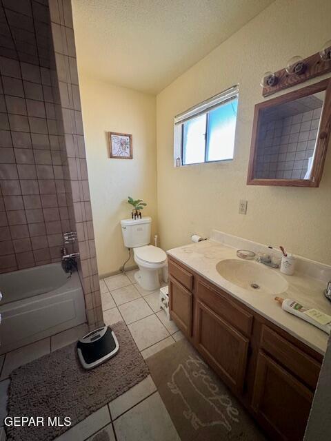 bathroom featuring tile patterned floors, toilet, vanity, shower / bath combination, and a textured ceiling