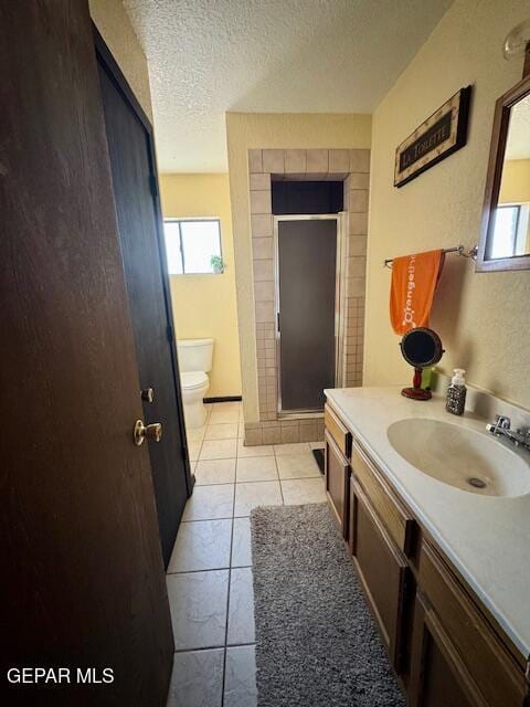 bathroom with a textured ceiling, a stall shower, healthy amount of natural light, toilet, and vanity