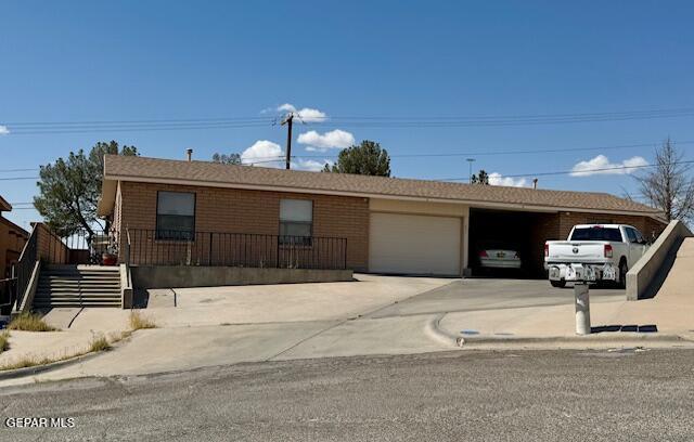 single story home featuring a garage, concrete driveway, and a carport