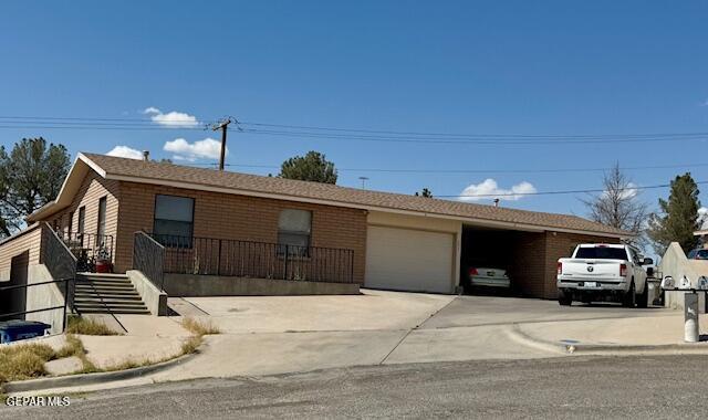 ranch-style house with a garage, driveway, and brick siding