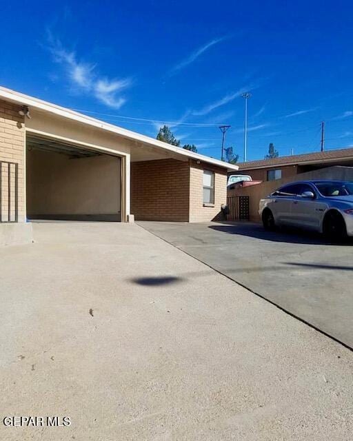 view of property exterior with brick siding, concrete driveway, and a garage