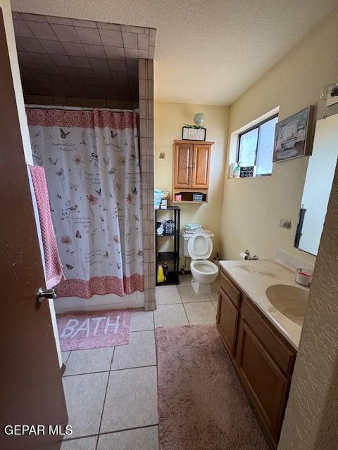 full bath with tile patterned flooring, vanity, toilet, and shower / bathtub combination with curtain