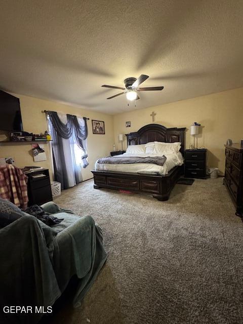 carpeted bedroom featuring a textured ceiling and a ceiling fan
