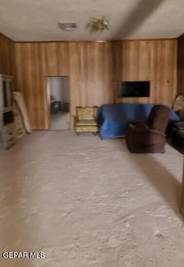 3433 Dialrock Ln, El Paso, TX 79935 - living area with wood walls and carpet flooring