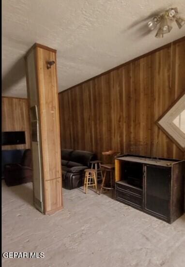 3433 Dialrock Ln, El Paso, TX 79935 - living room with wooden walls and a textured ceiling