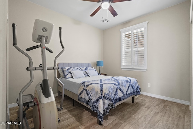 bedroom with wood finished floors, baseboards, and ceiling fan