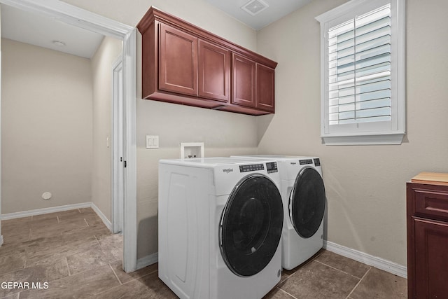 clothes washing area with independent washer and dryer, baseboards, and cabinet space