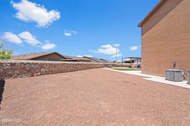 view of yard featuring fence, central AC, and a patio area