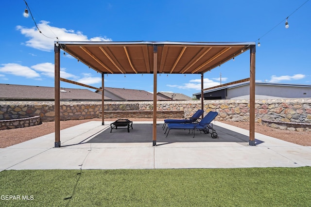 view of patio with an outdoor fire pit and fence
