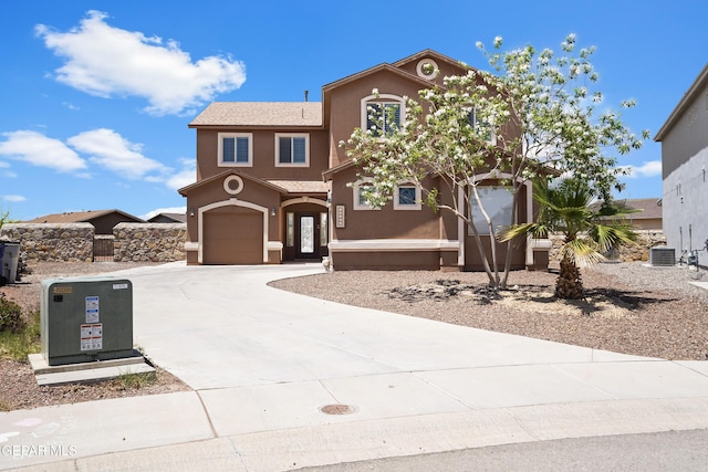 view of front of house with stucco siding, central air condition unit, driveway, and an attached garage