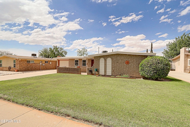 ranch-style house featuring driveway, a front lawn, an attached garage, and brick siding