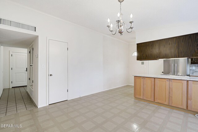 kitchen with a chandelier, light countertops, crown molding, light flooring, and pendant lighting