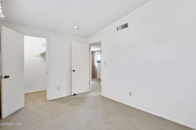 unfurnished bedroom featuring a walk in closet, baseboards, and a closet