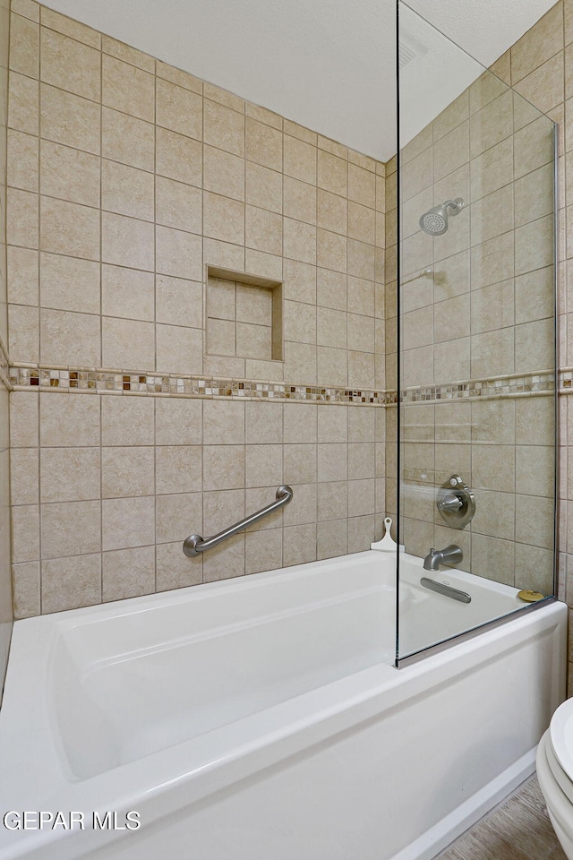 bathroom featuring shower / washtub combination and toilet