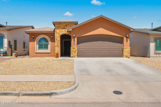 mediterranean / spanish-style home featuring stone siding, stucco siding, an attached garage, and concrete driveway