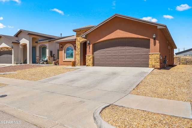 mediterranean / spanish-style home with stone siding, stucco siding, a garage, and concrete driveway